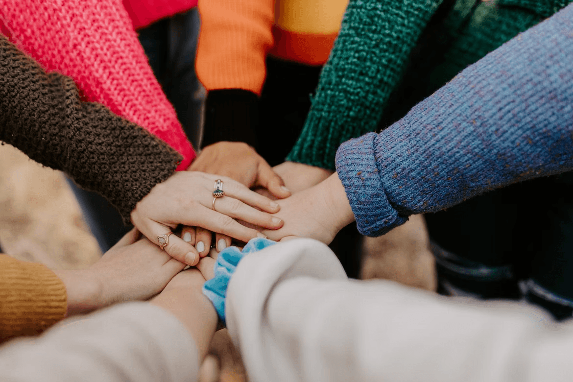 a team huddle with everyones hands in